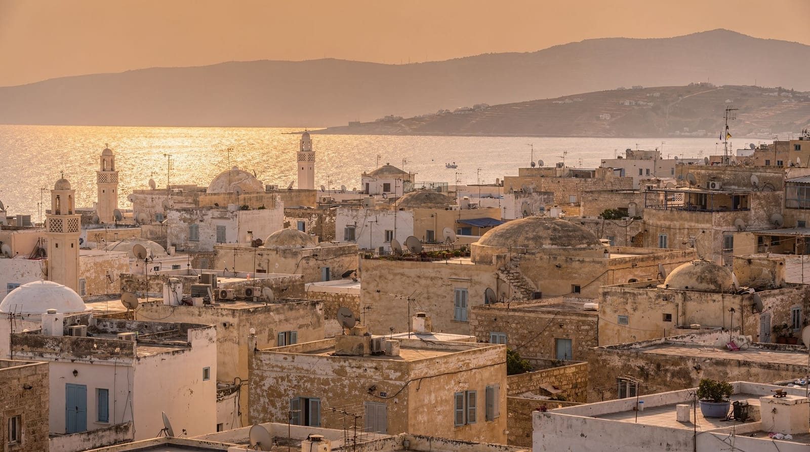 Les toits de la médina de Tunis au crépuscule, avec la baie de Tunis au loin
